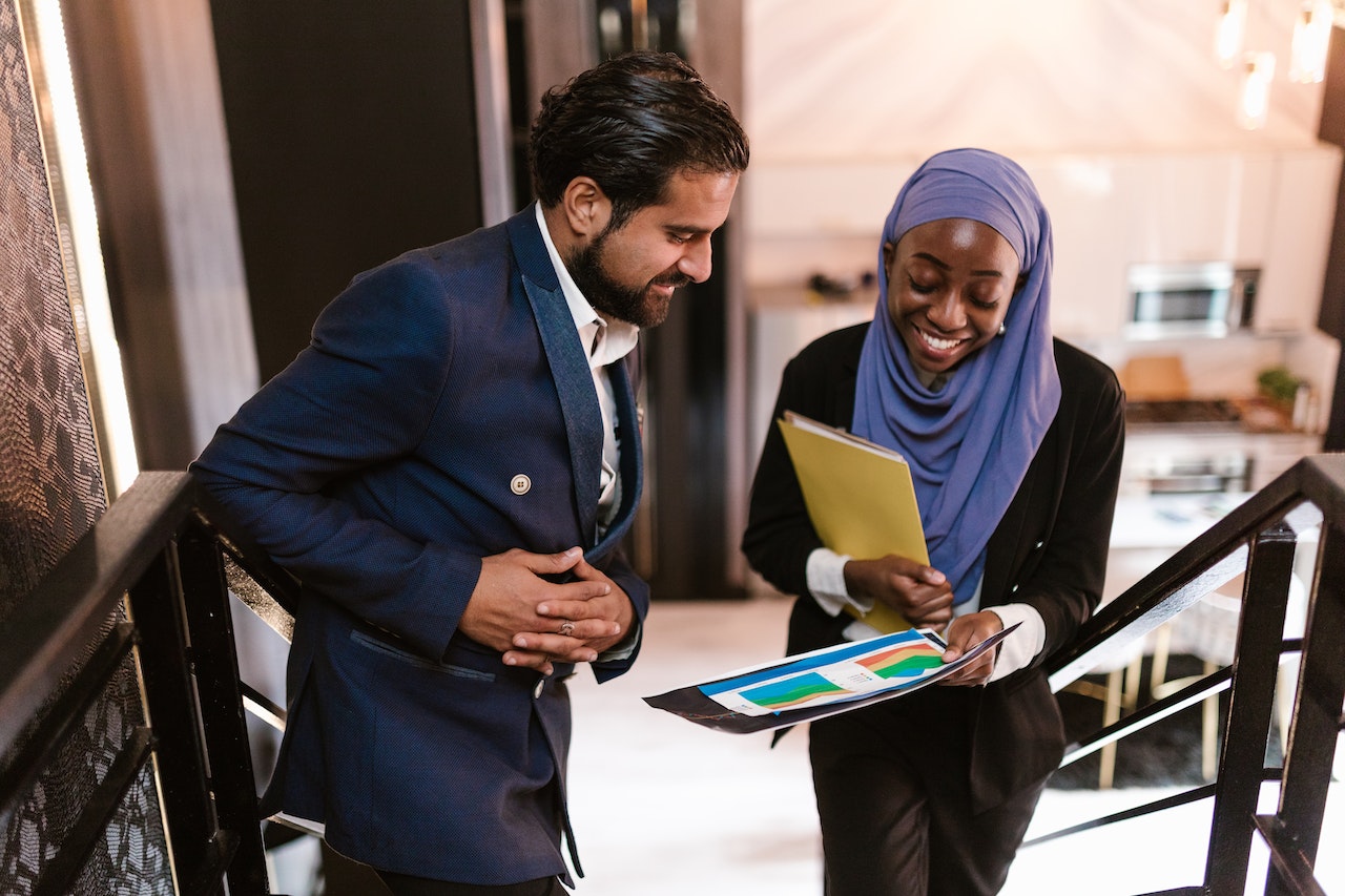 Arab Man and Lady Reviewing Business Document