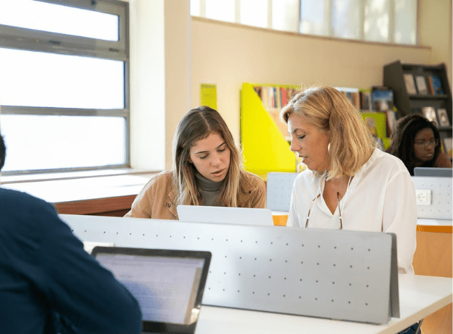 Diverse students doing research with teacher