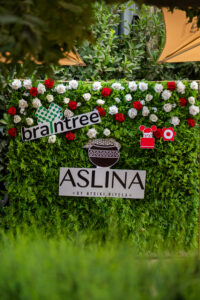 a bush with roses on it a banner saying "aslina by mtsiki biyela" and a banner of Braintree's logo outside the Accelerate Action: A Creative Brunch for Women in Business Leadership function
