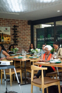 women sitting at dining tables listening to an off screen speaker at the Accelerate Action: A Creative Brunch for Women in Business Leadership function