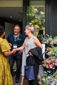 three people conversing and laughing outside the Accelerate Action: A Creative Brunch for Women in Business Leadership function