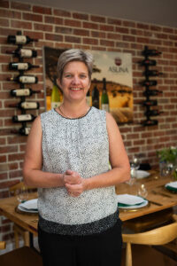 woman standing in front of a dining table smiling at the Accelerate Action: A Creative Brunch for Women in Business Leadership function