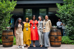 five women standing between two Aslina wine barrels at the Accelerate Action: A Creative Brunch for Women in Business Leadership function