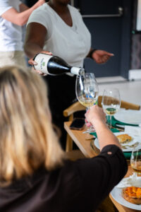 woman getting her wine glas filled at the Accelerate Action: A Creative Brunch for Women in Business Leadership function