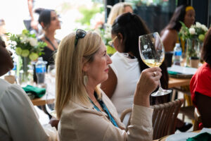 woman holding up a glass of wine at the Accelerate Action: A Creative Brunch for Women in Business Leadership function