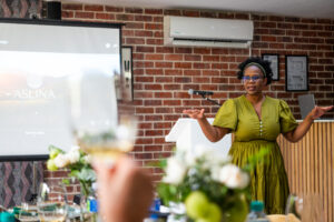 woman in a green dress sopeaking at the Accelerate Action: A Creative Brunch for Women in Business Leadership function