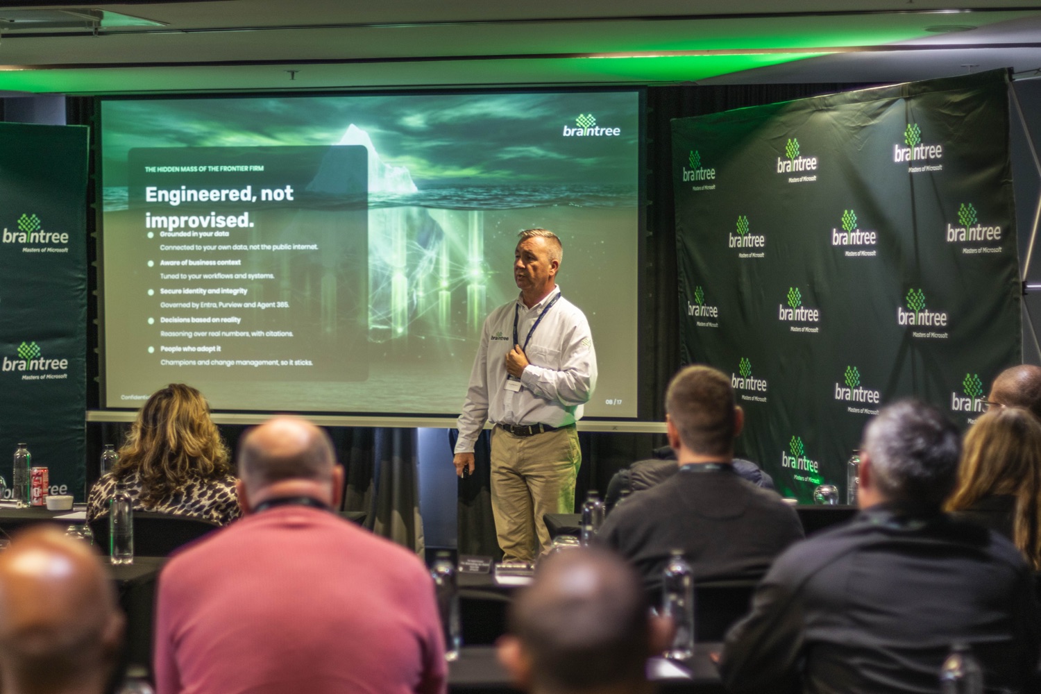 A speaker presenting to the room beside the Braintree branded screen