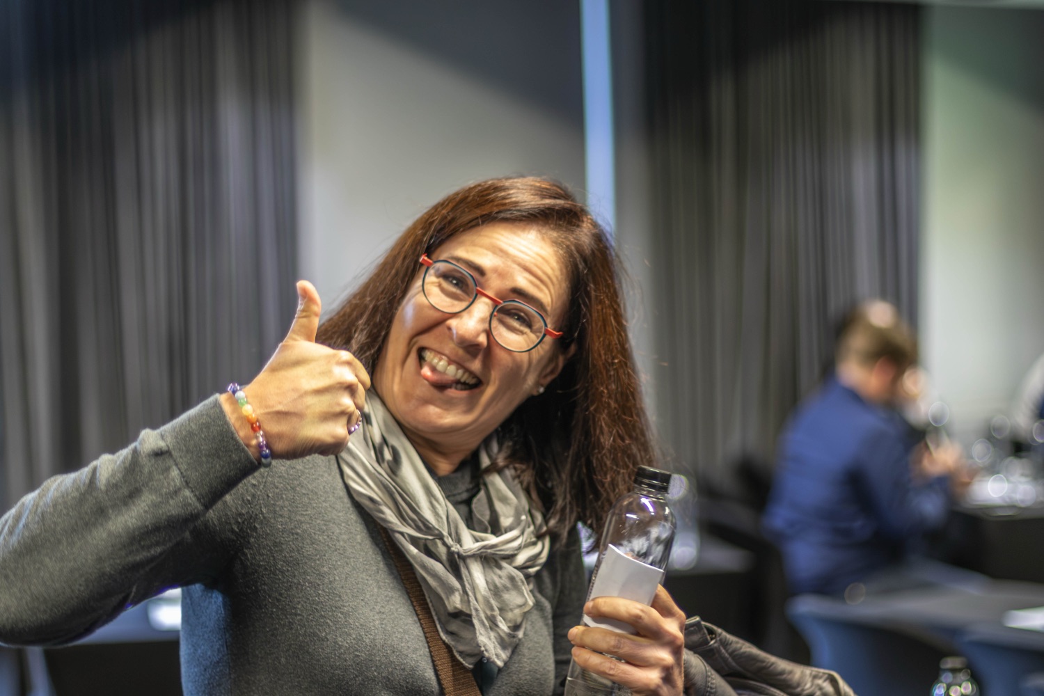 A guest giving an enthusiastic thumbs-up with a glass in hand