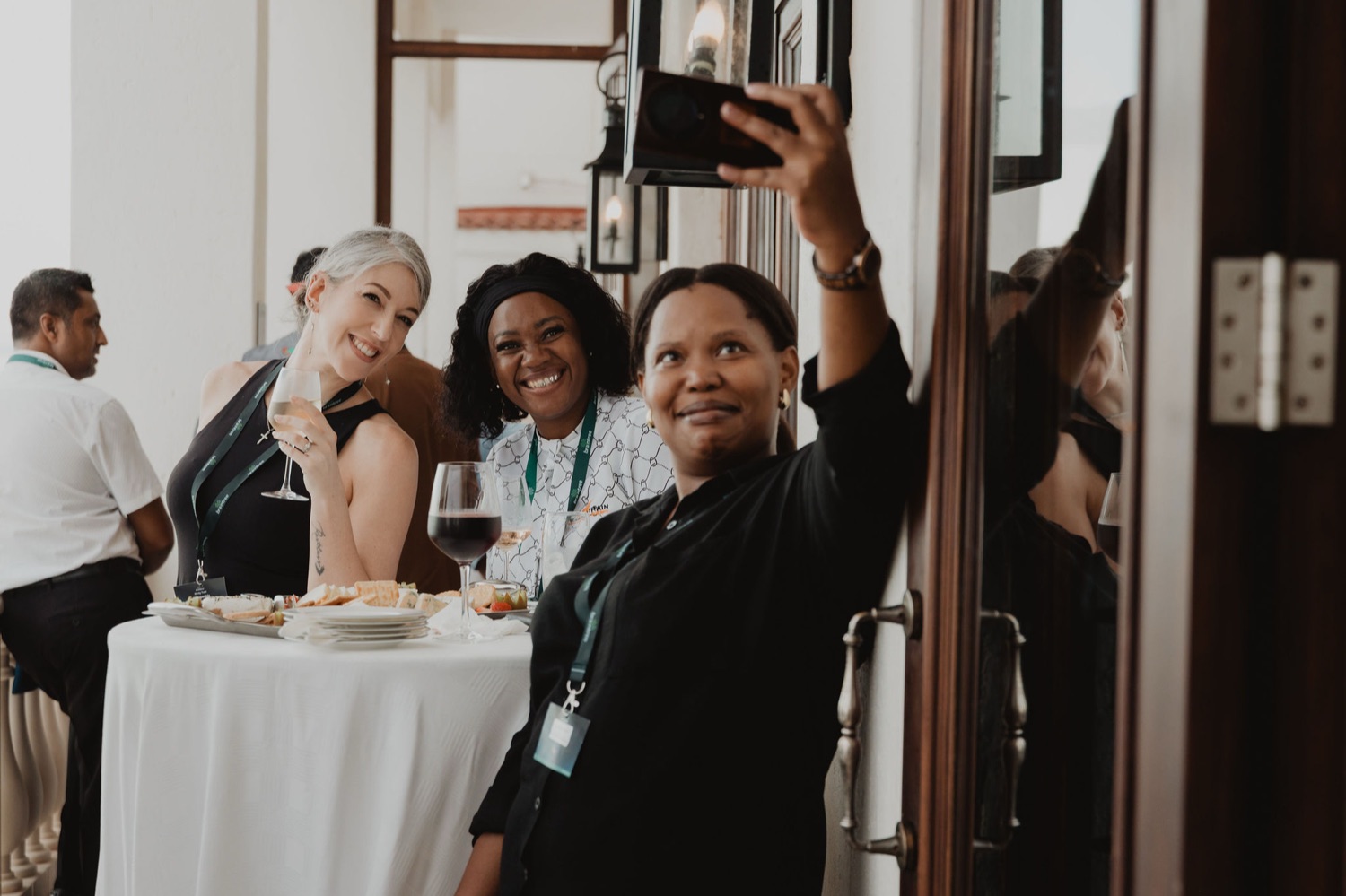 Guests laughing together at a doorway during the reception