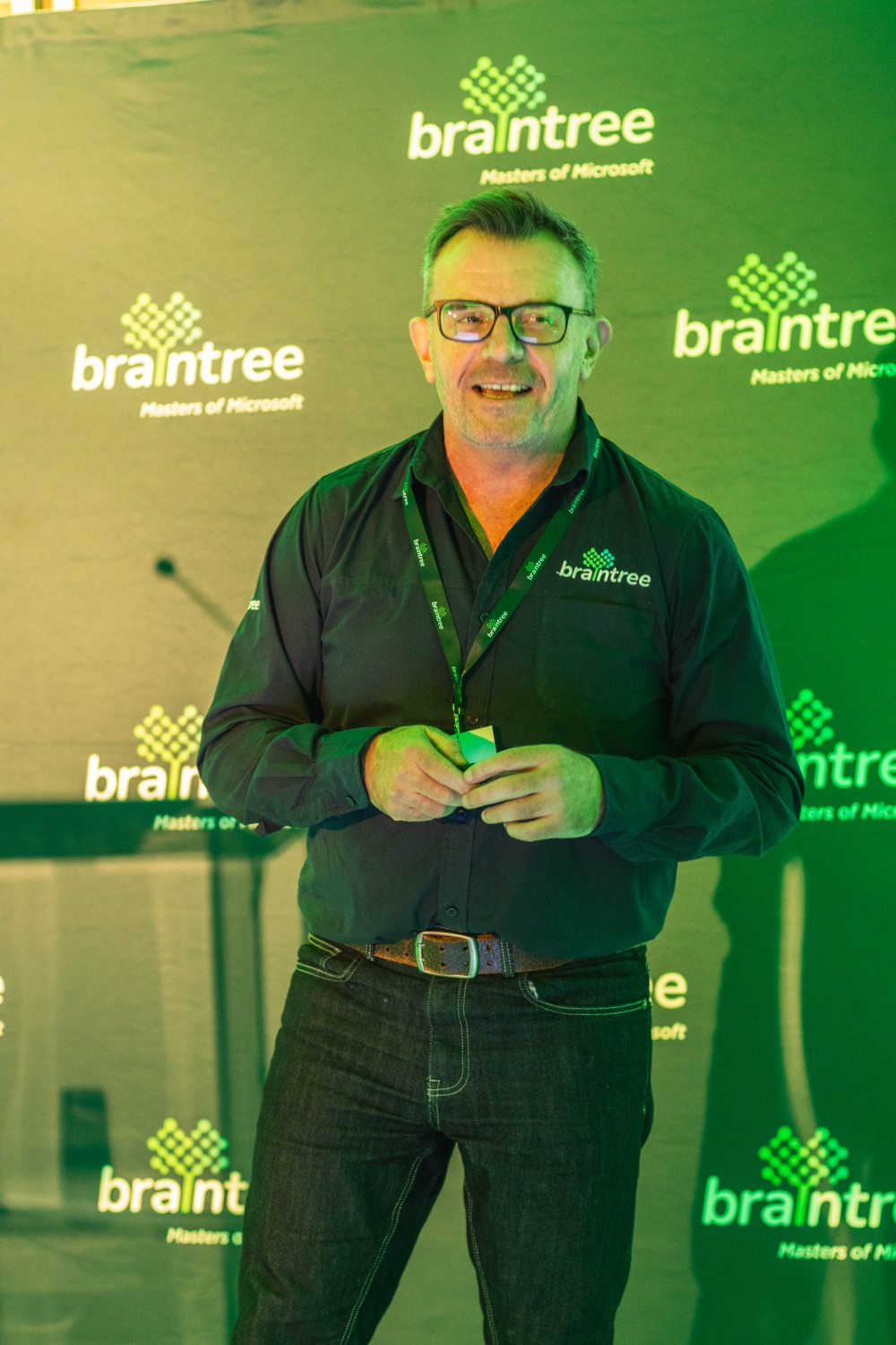 A presenter addressing the room in front of the Braintree backdrop
