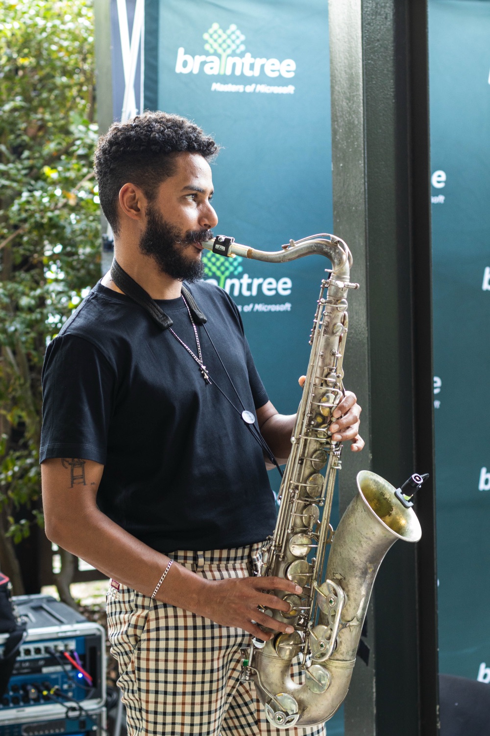 A live saxophonist performing in front of a Braintree branded backdrop
