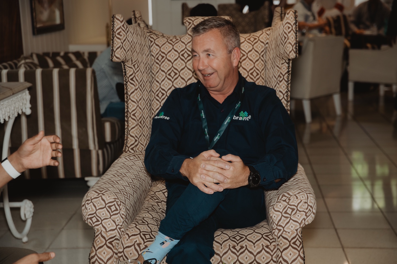 A guest wearing a lanyard relaxing in a lounge chair