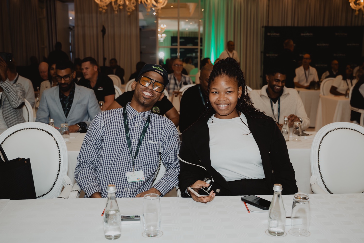 Guests smiling together at a table during a session