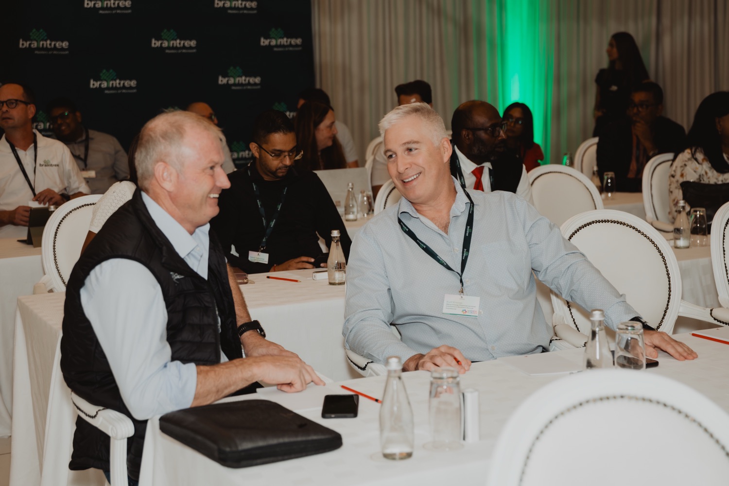 Two guests in conversation in front of the Braintree backdrop