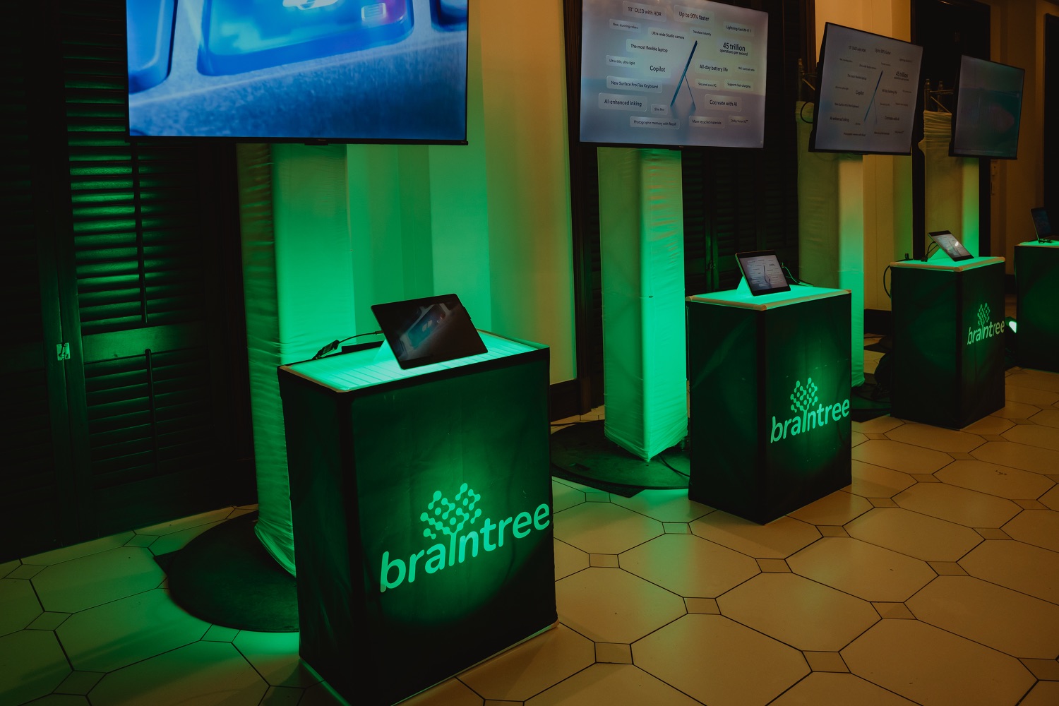 Illuminated branded lecterns lit in green on the stage