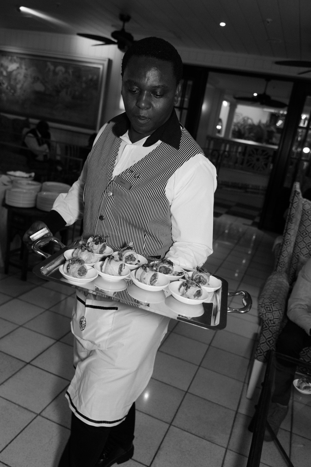 A member of the catering team presenting a tray of canapes