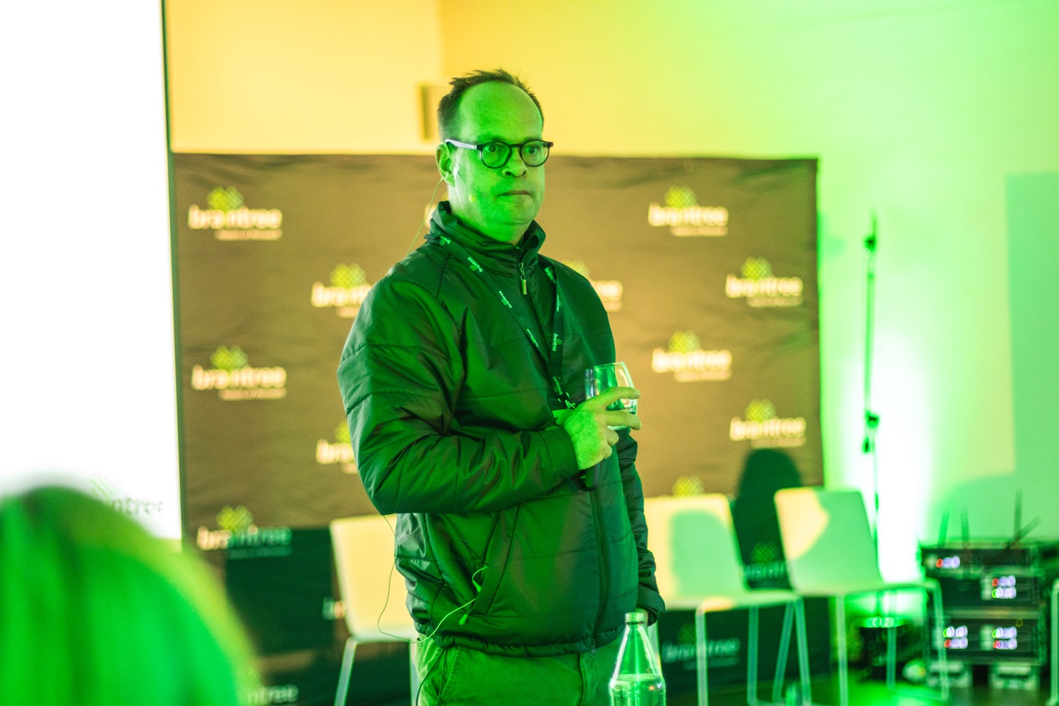 A speaker engaging the audience against the braintree backdrop