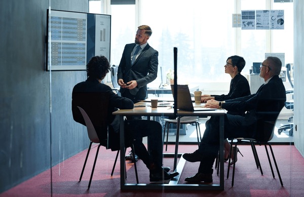 Executives reviewing performance data on a wall screen
