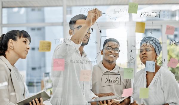 A team planning their rollout at a glass wall